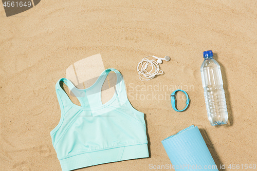 Image of sports top, mat, fitness tracker and water bottle