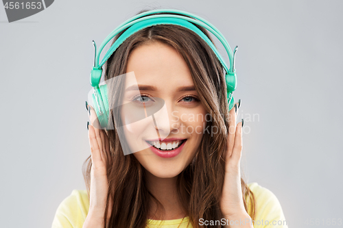 Image of happy young woman or teenage girl with headphones