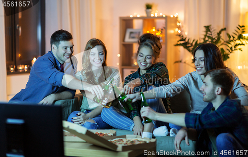 Image of friends with drinks and pizza watching tv at home