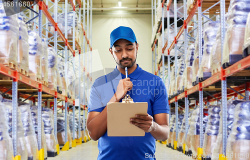 Image of indian delivery man with clipboard at warehouse