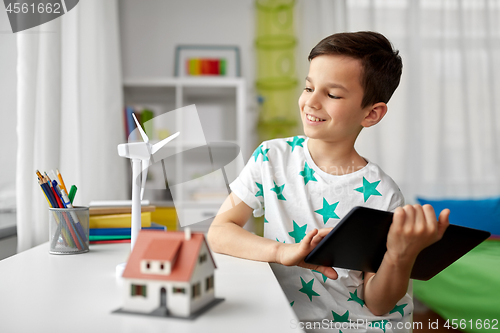 Image of boy with tablet, toy house and wind turbine