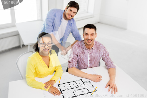 Image of creative team with blueprint working at office