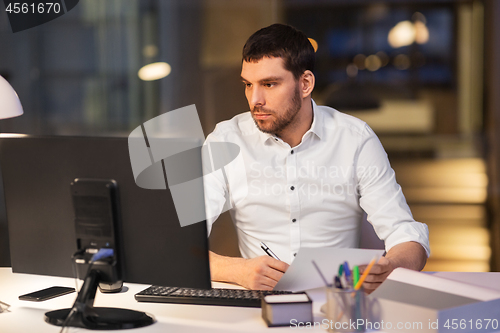 Image of businessman with computer working at night office