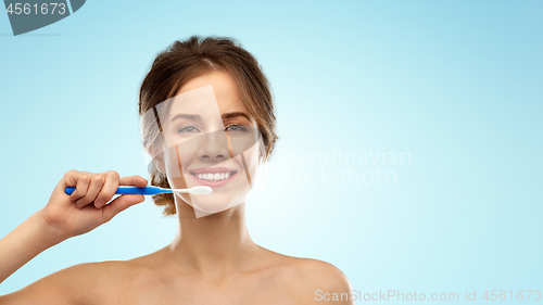 Image of smiling woman with toothbrush cleaning teeth