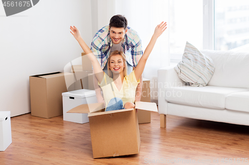 Image of happy couple having fun with boxes at new home