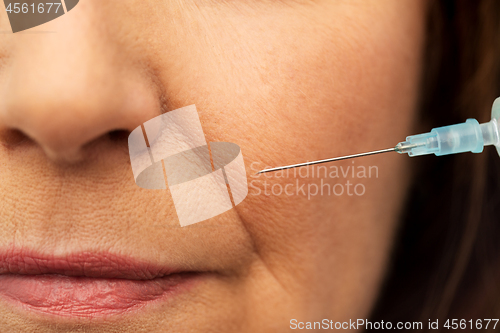 Image of close up of senior woman face and syringe