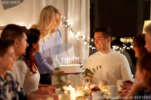 Image of  happy family with cake having birthday party