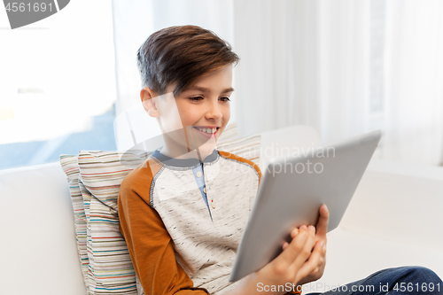 Image of smiling boy with tablet pc computer at home