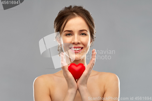 Image of beautiful smiling woman holding red heart