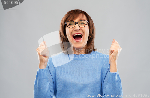 Image of portrait of happy senior woman celebrating triumph