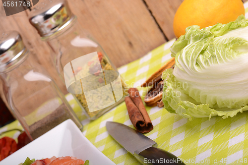 Image of fresh salmon fillet on white plate. knife, cabbage, red pepper, spice, cinnamon and lemon