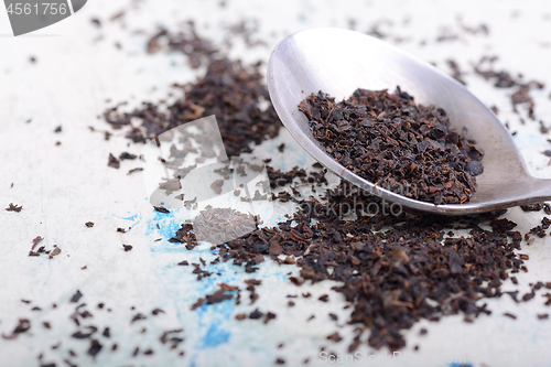 Image of Black tea in a spoon on a white background. Close up shot