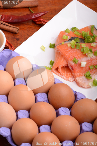 Image of fresh salmon fillet close up on white plate. red pepper, eggs and lemon