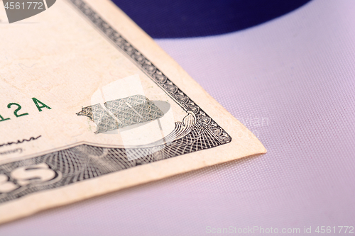 Image of ten dollar bill in front of the American flag