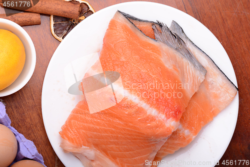 Image of fresh salmon fillet close up on white plate. eggs, cinnamon and lemon