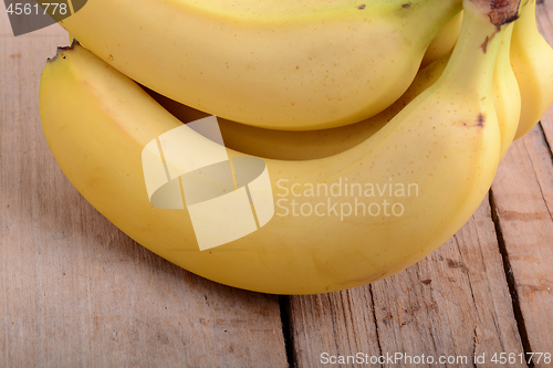 Image of bunch of yellow Bananas in a Wooden background