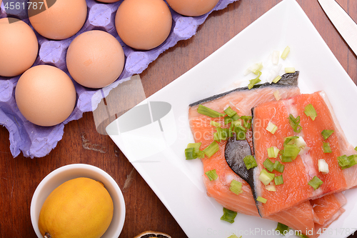 Image of fresh salmon fillet close up on white plate. eggs and lemon