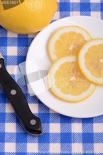 Image of Halved lemon and a knife on a white plate