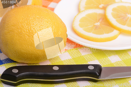 Image of Halved lemon and a knife on a white plate