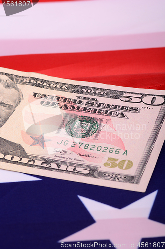 Image of fifty dollar bill in front of the American flag