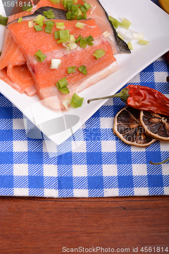 Image of fresh salmon fillet on white plate. red pepper, cinnamon and lemon