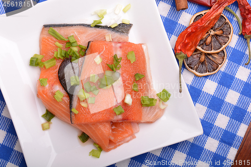 Image of fresh salmon fillet on white plate. red pepper, cinnamon and lemon