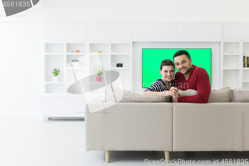 Image of couple hugging and relaxing on sofa