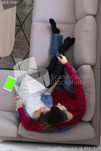 Image of Young couple on the sofa watching television top view