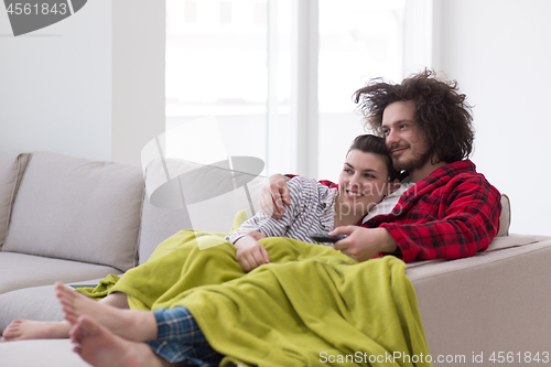 Image of Young couple on the sofa watching television