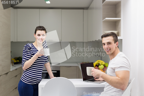 Image of couple with laptop computer enjoying morning