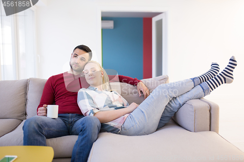 Image of couple hugging and relaxing on sofa