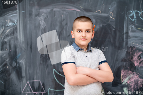 Image of portrait of little boy in front of chalkboard