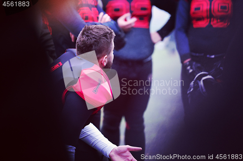 Image of american football player discussing strategy with his team