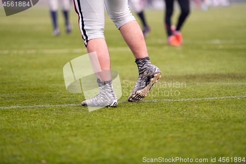 Image of close up of american football players stretching and warming up