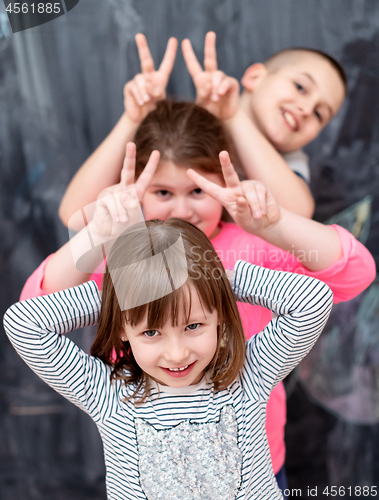 Image of group of kids standing in front of chalkboard