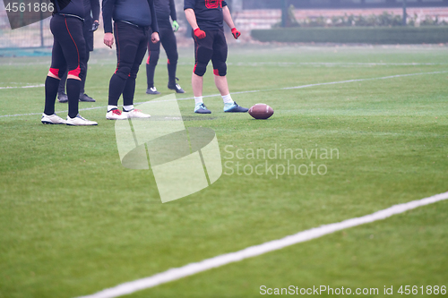 Image of group of american football players practicing football kickoff