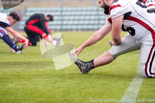 Image of american football players stretching and warming up