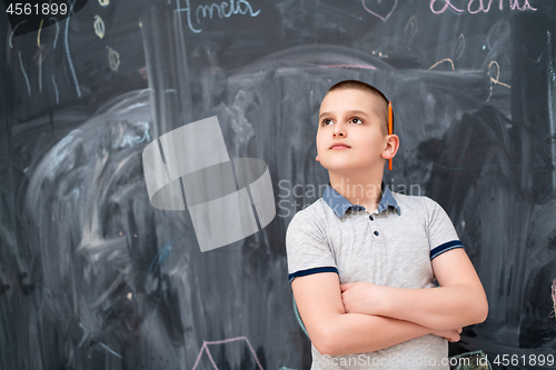 Image of portrait of little boy in front of chalkboard
