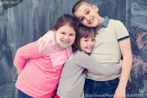 Image of group of kids hugging in front of chalkboard