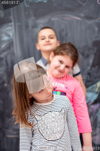 Image of group of kids standing in front of chalkboard