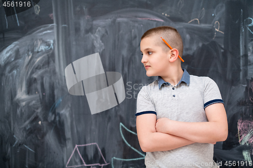 Image of portrait of little boy in front of chalkboard