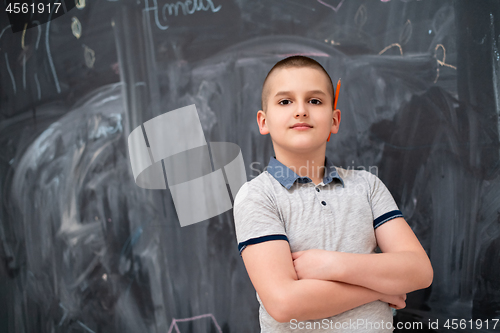 Image of portrait of little boy in front of chalkboard