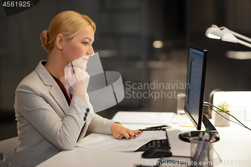 Image of businesswoman at computer working at night office