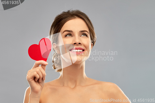 Image of beautiful smiling woman holding red heart