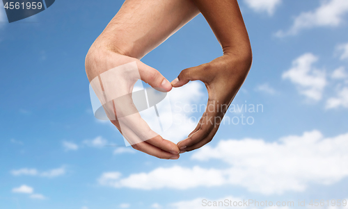 Image of hands of different skin color making heart shape