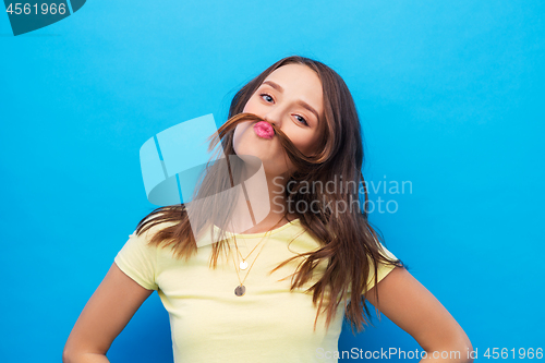 Image of young woman making mustache with her hair