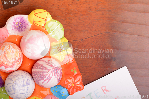 Image of Easter eggs and white paper on a wooden background