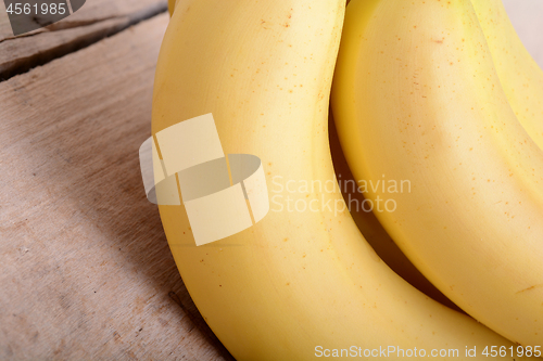 Image of bunch of yellow Bananas in a Wooden background