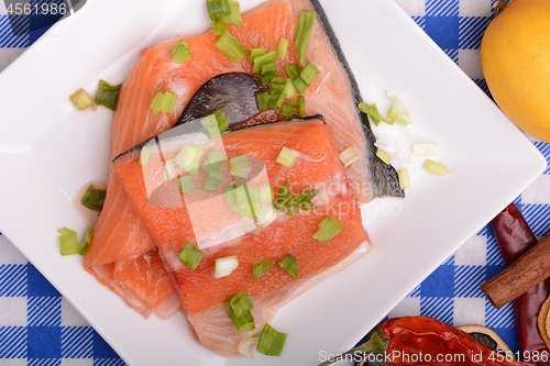 Image of fresh salmon fillet on white plate. red pepper, cinnamon and lemon