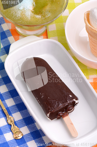 Image of Chocolate ice cream on white plate and green ice. top view